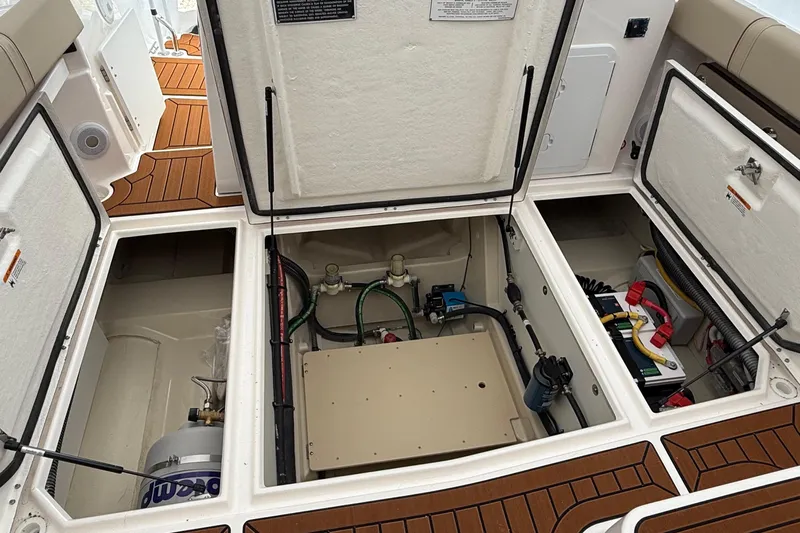  Yacht Photos Pics 2025 Ranger Tugs R-25 boat interior compartments with open hatches, showcasing storage and equipment.