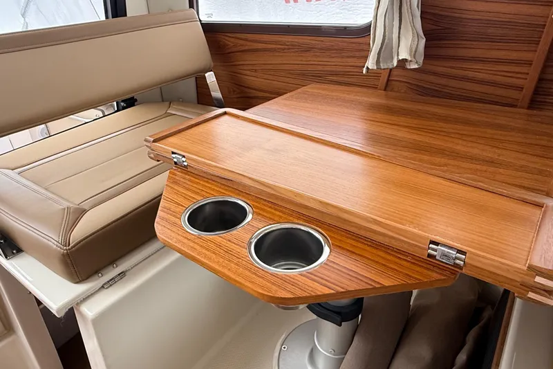  Yacht Photos Pics 2025 Ranger Tugs R-25 interior with wooden table and cup holders.