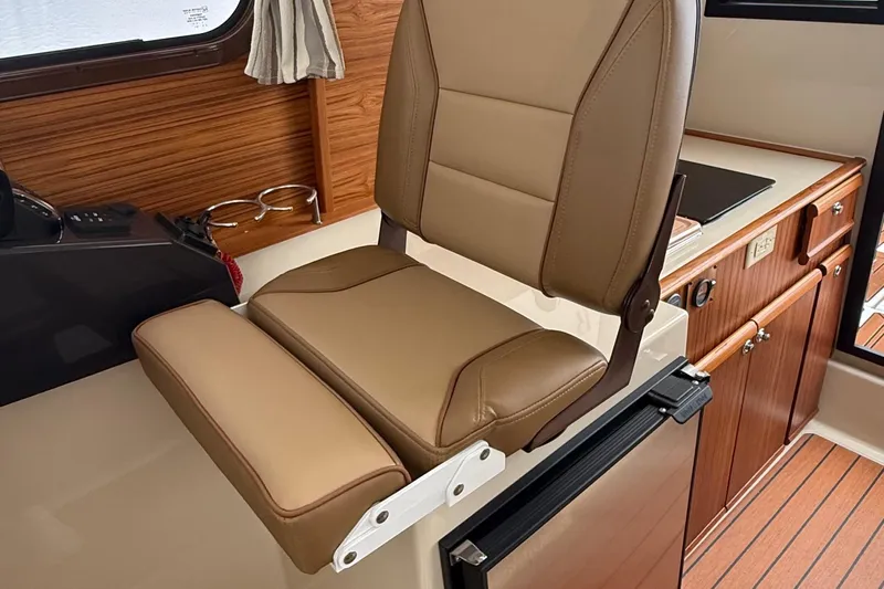  Yacht Photos Pics 2025 Ranger Tugs R-25 interior with tan seating and wooden cabinetry.