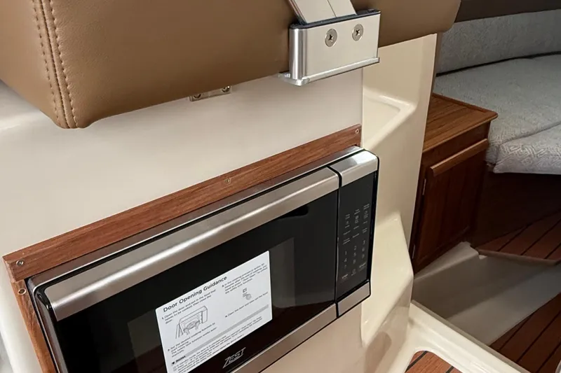  Yacht Photos Pics 2025 Ranger Tugs R-25 interior with microwave and wooden cabinetry.