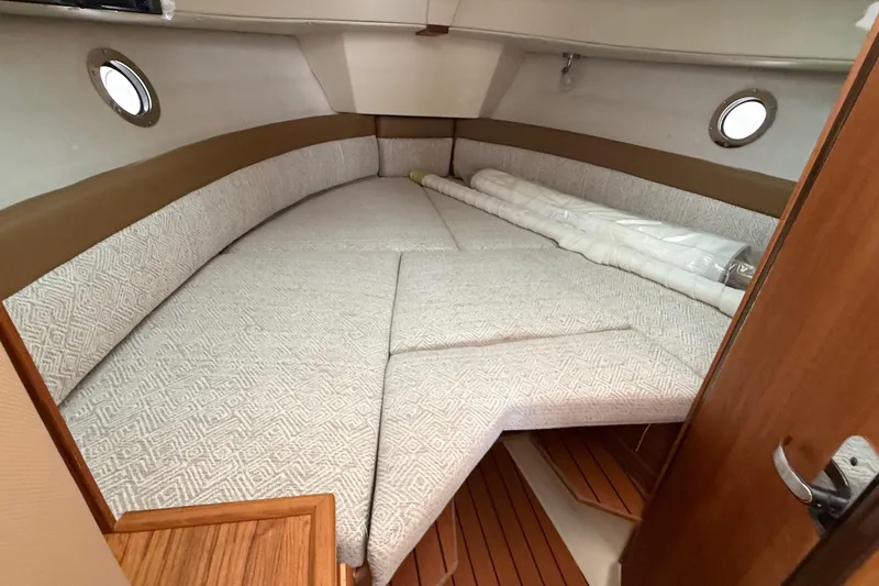  Yacht Photos Pics Cozy interior cabin of 2025 Ranger Tugs R-25 with comfortable bedding and wooden accents.