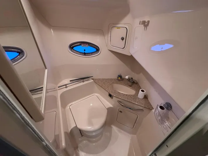 Skeeter Yacht Photos Pics 2004 Sea Ray 420 Sundancer bathroom with sink, toilet, and porthole window.