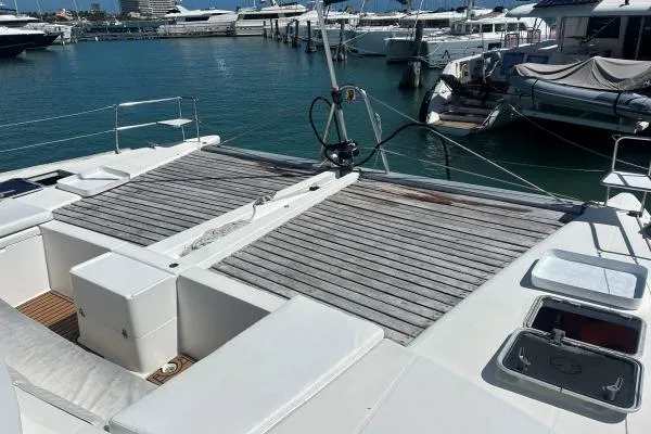 Quidam Yacht Photos Pics 2004 Lagoon 440 catamaran docked at marina, featuring spacious deck and seating area.