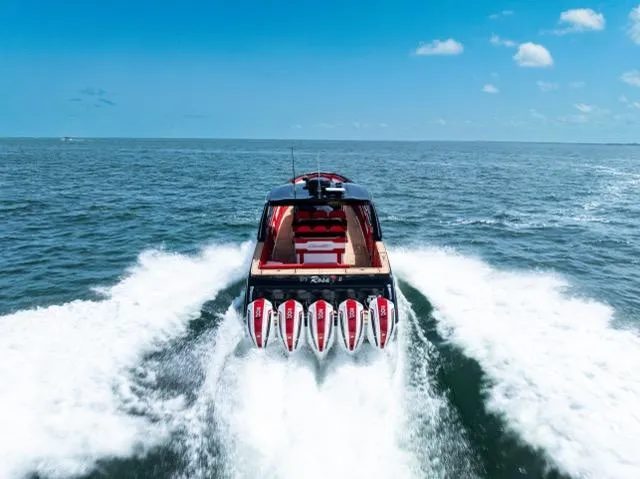  Yacht Photos Pics 2025 Cigarette 42 Auroris speedboat cruising on open ocean under clear blue sky.