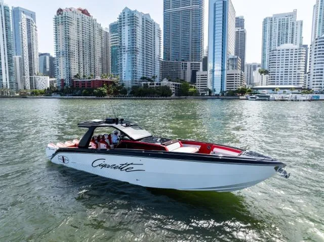  Yacht Photos Pics 2025 Cigarette 42 Auroris boat cruising in urban waterfront with skyscrapers in background.