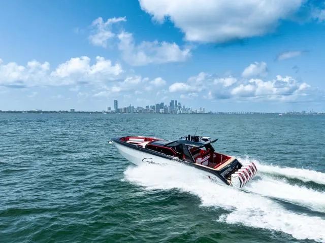  Yacht Photos Pics 2025 Cigarette 42 Auroris speedboat cruising on ocean with city skyline in background.