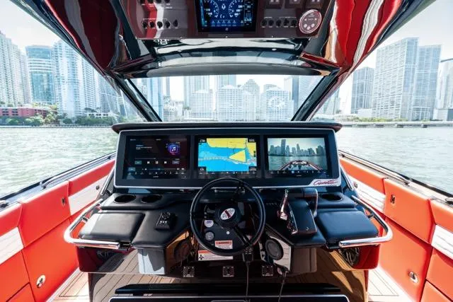  Yacht Photos Pics Cockpit of 2025 Cigarette 42 Auroris boat with advanced navigation systems, city skyline in background.