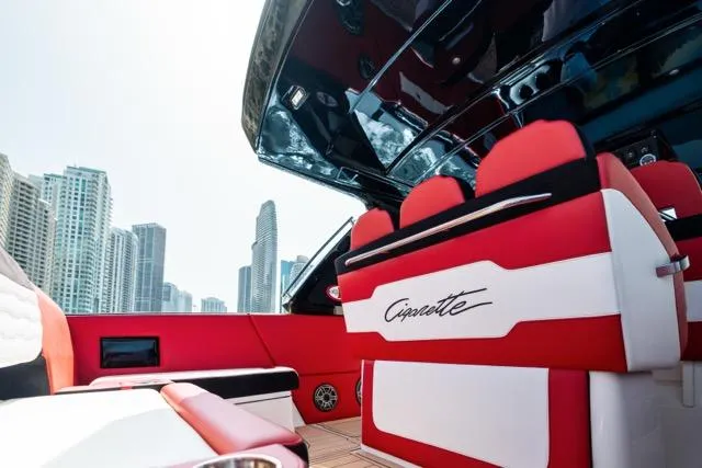  Yacht Photos Pics Luxurious 2025 Cigarette 42 Auroris boat interior with red and white seating, city skyline backdrop.