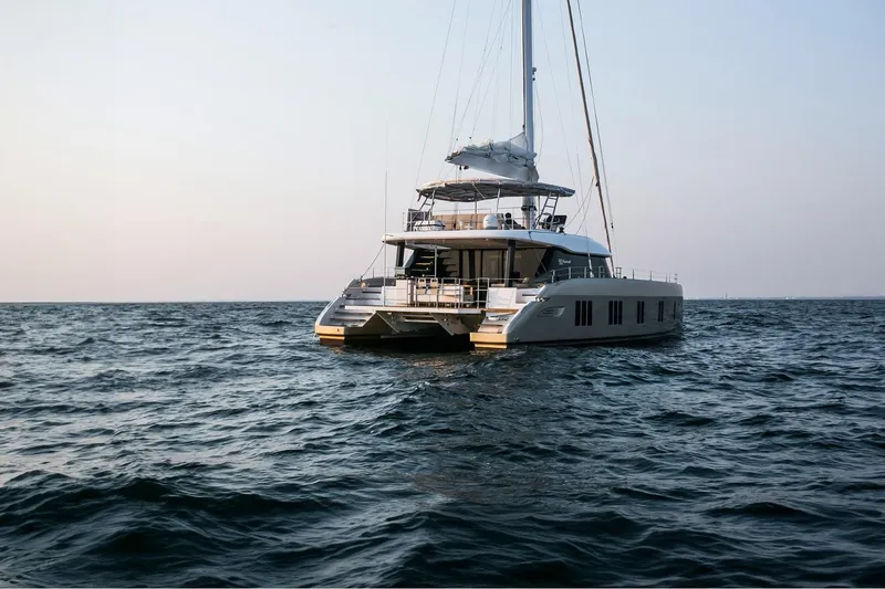 Surf Soul Yacht Photos Pics Luxurious 2023 Sunreef 50 catamaran sailing on open sea at sunset.