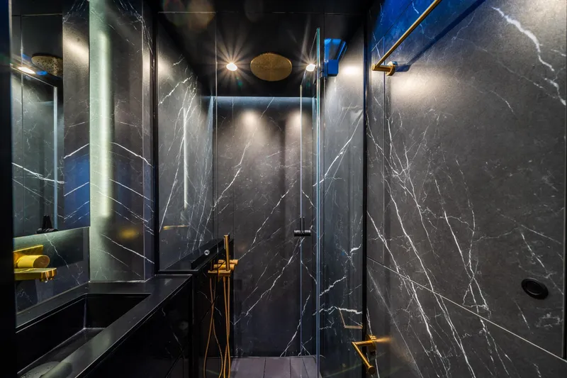 Surf Soul Yacht Photos Pics Luxurious bathroom in 2023 Sunreef 50 yacht with elegant black marble and gold accents.