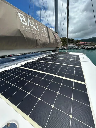 Voyager Yacht Photos Pics 2023 Bali 5.4 yacht with solar panels, docked in a marina under a cloudy sky.