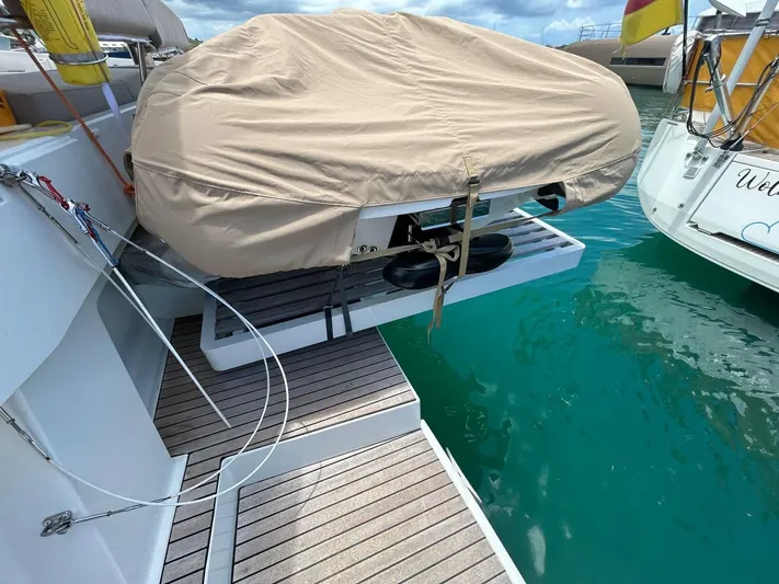 Voyager Yacht Photos Pics Covered dinghy on a 2023 Bali 5.4 yacht platform, docked in clear turquoise water.