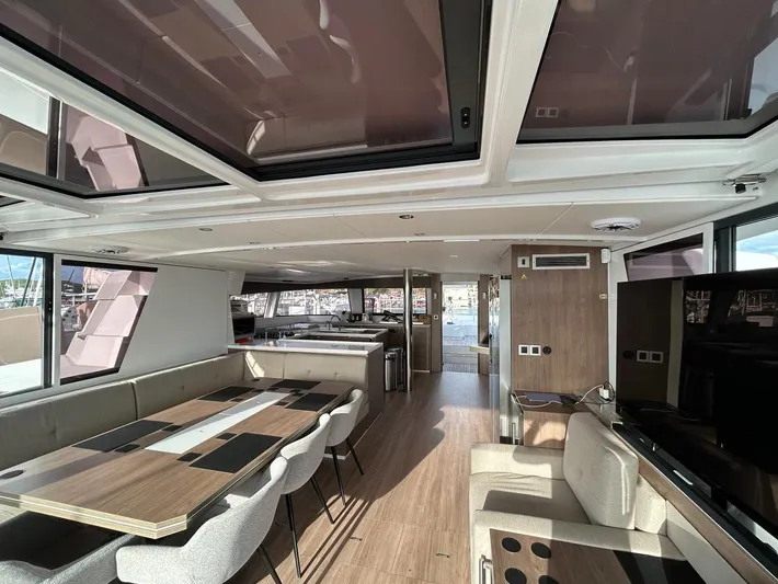 Voyager Yacht Photos Pics Luxurious interior of 2023 Bali 5.4 yacht with modern dining area and panoramic windows.