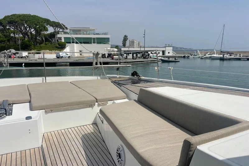 Voyager Yacht Photos Pics Luxurious Bali 5.4 yacht deck with sun loungers, docked in a serene marina, 2023 model.