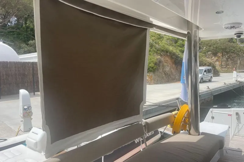 Voyager Yacht Photos Pics Outdoor seating area on a 2023 Bali 5.4 yacht, featuring a sunshade and dockside view.