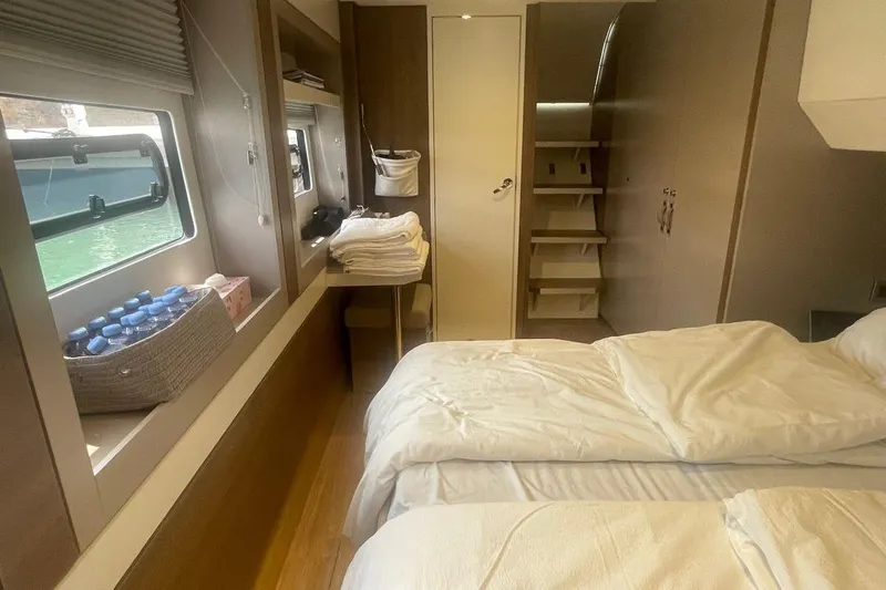 Voyager Yacht Photos Pics Cozy cabin interior of 2023 Bali 5.4 yacht with bed, window, and stairs.