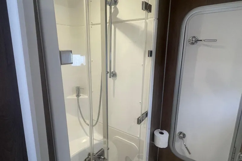 Voyager Yacht Photos Pics Compact bathroom in 2023 Bali 5.4 model, featuring a shower and toilet paper holder.