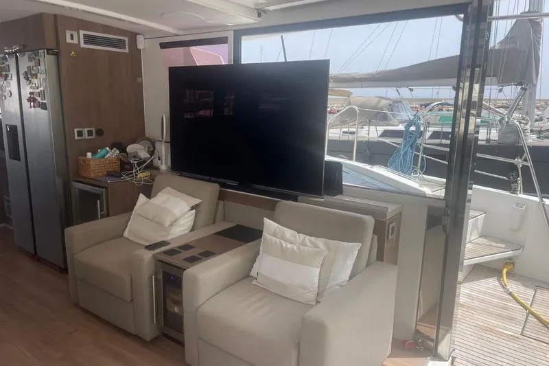 Voyager Yacht Photos Pics Luxurious interior of 2023 Bali 5.4 yacht with plush seating and large TV.