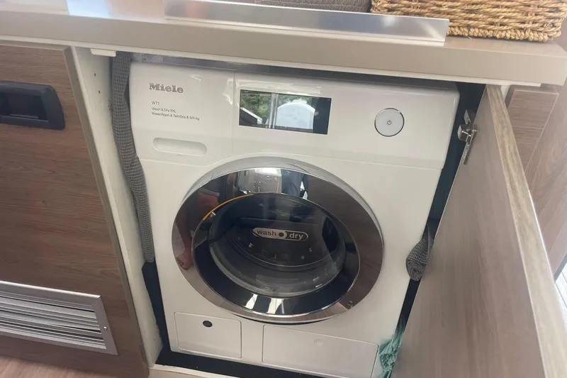 Voyager Yacht Photos Pics Compact Miele washer-dryer in a Bali 5.4 model, 2023, integrated into cabinetry.