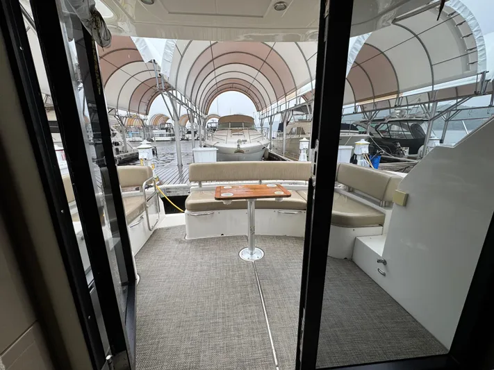 Casa De Luz Yacht Photos Pics 2014 Carver C40 Command Bridge yacht interior with seating and table, docked under canopy.