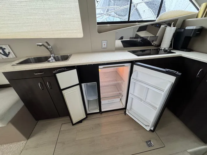 Casa De Luz Yacht Photos Pics Kitchen area of 2014 Carver C40 Command Bridge with open fridge and dual sinks.