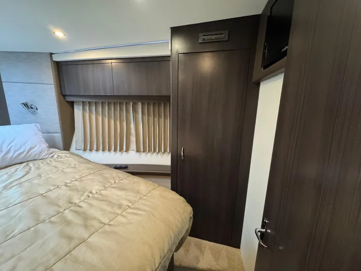 Casa De Luz Yacht Photos Pics Bedroom interior of 2014 Carver C40 Command Bridge with wood paneling and cozy bedding.