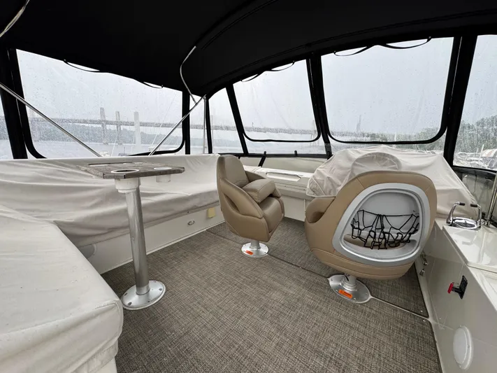 Casa De Luz Yacht Photos Pics 2014 Carver C40 Command Bridge interior with covered seating and helm, featuring panoramic windows.