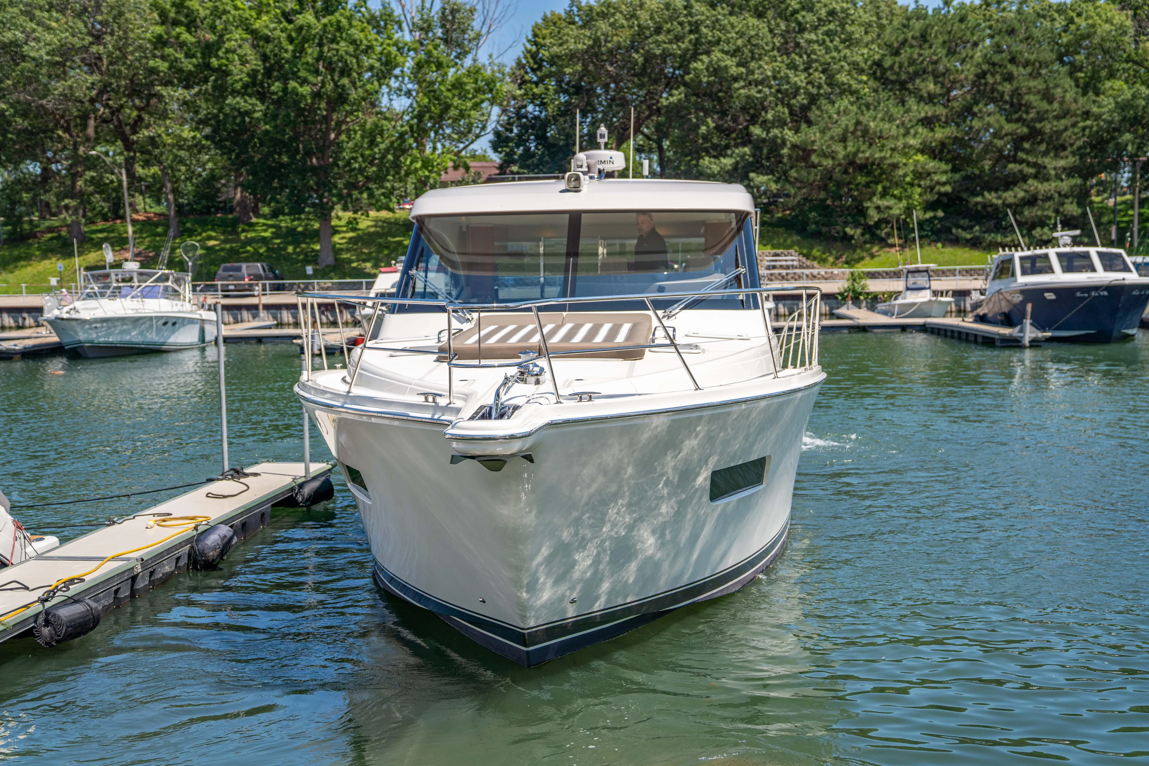  Yacht Photos Pics 2020 Riviera 525 SUV docked in a serene marina setting.
