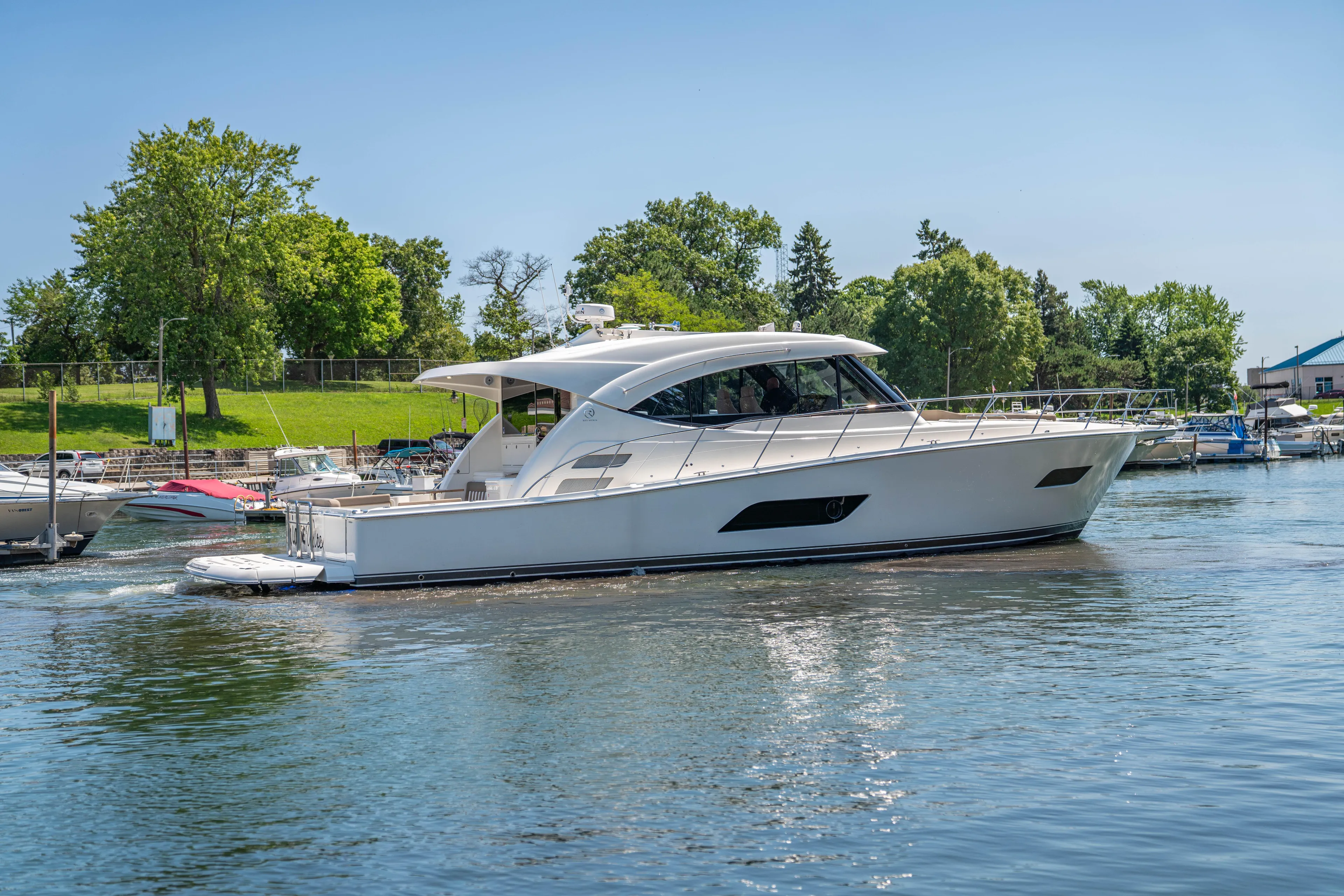  Yacht Photos Pics 2020 Riviera 525 SUV yacht cruising on a serene lake.