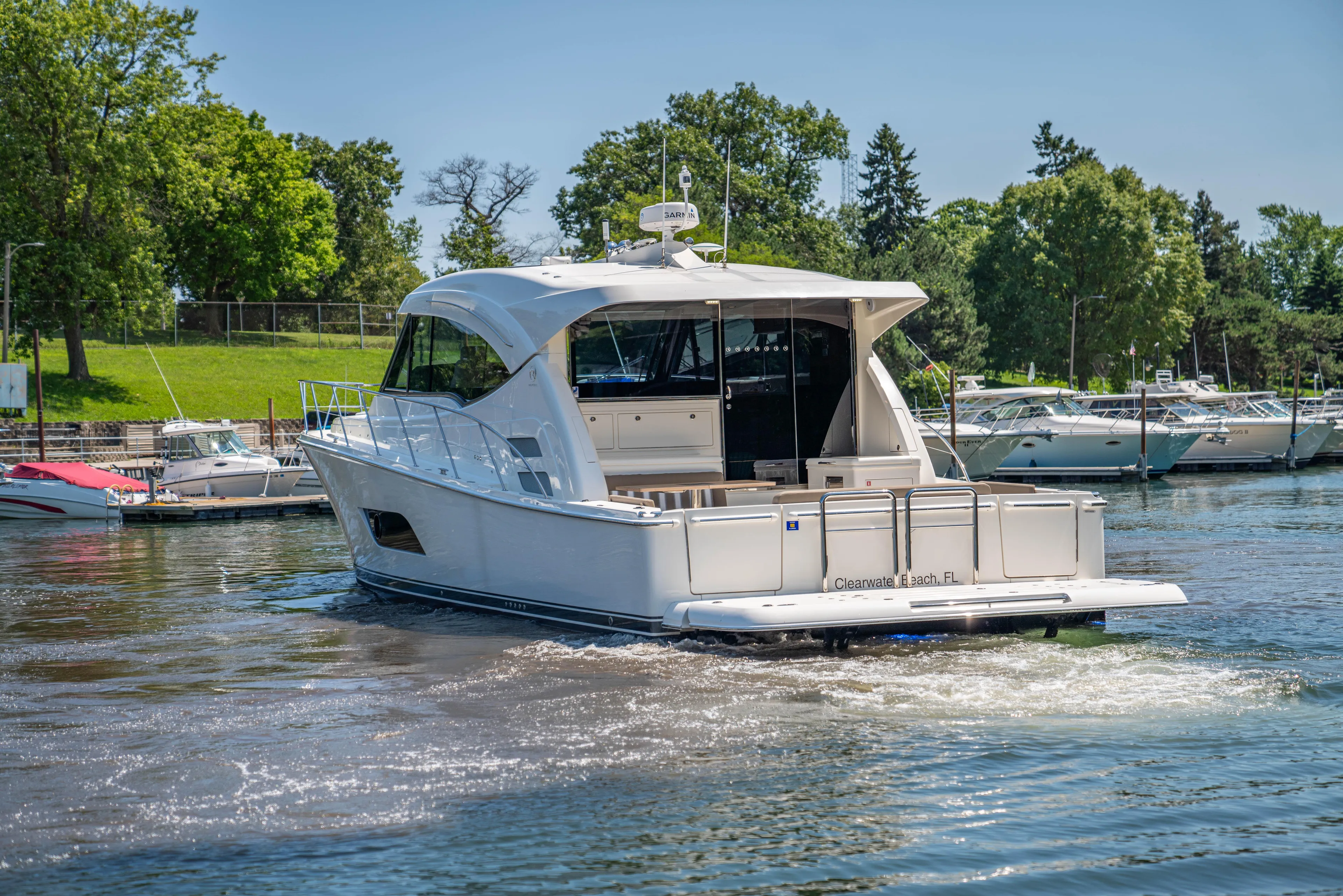  Yacht Photos Pics 2020 Riviera 525 SUV cruising on a sunny day in a marina.