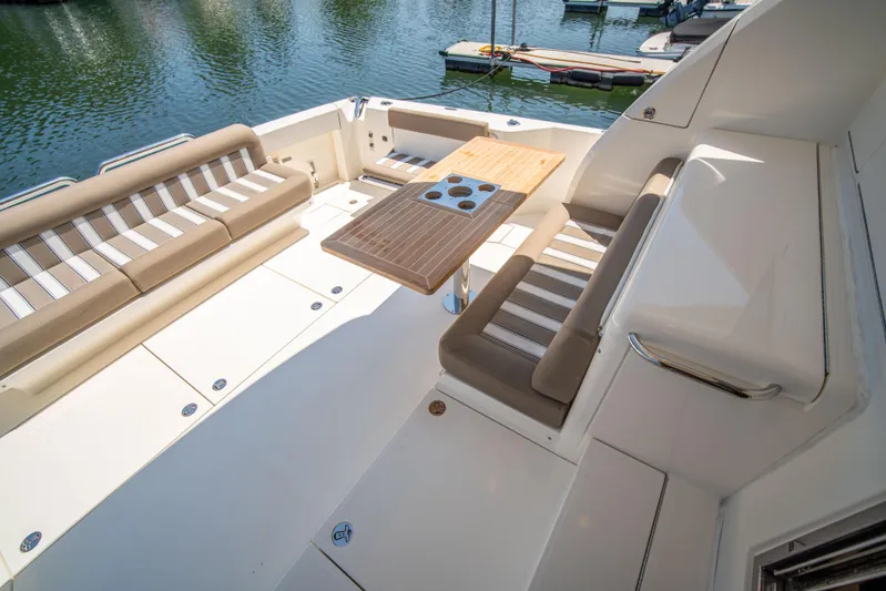  Yacht Photos Pics 2020 Riviera 525 SUV yacht deck with seating and table, docked by the water.