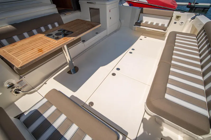  Yacht Photos Pics 2020 Riviera 525 SUV interior with striped seating and wooden table.