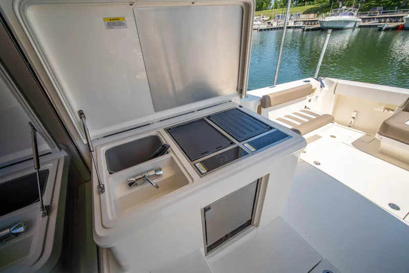  Yacht Photos Pics Riviera 525 SUV 2020 yacht with outdoor kitchenette and sink by the water.