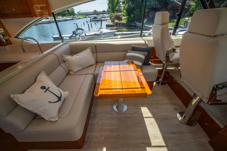  Yacht Photos Pics Luxurious interior of 2020 Riviera 525 SUV yacht with elegant seating and wooden table.