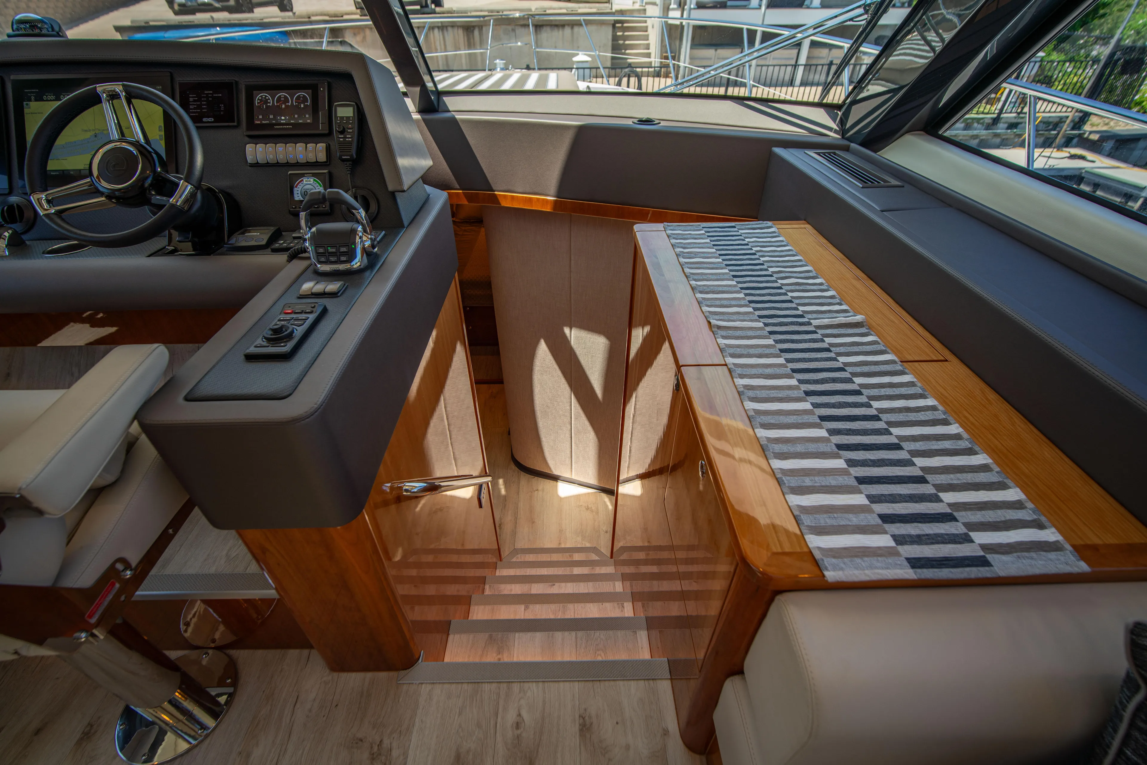  Yacht Photos Pics Interior of 2020 Riviera 525 SUV yacht, featuring helm and wooden staircase.