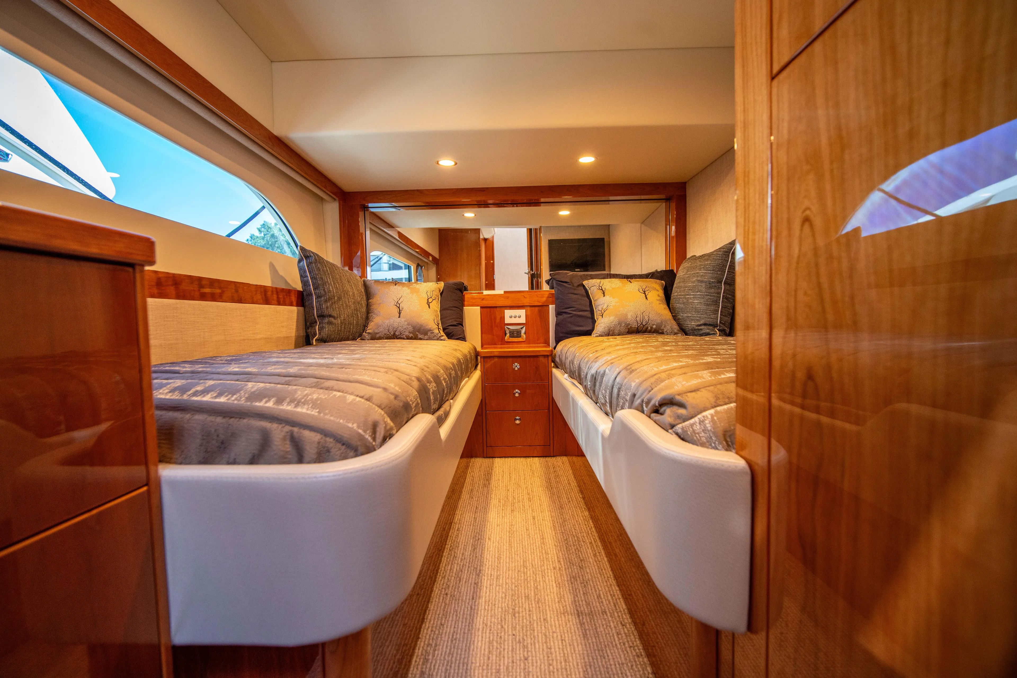  Yacht Photos Pics Luxurious interior of 2020 Riviera 525 SUV with twin beds and elegant wood finish.