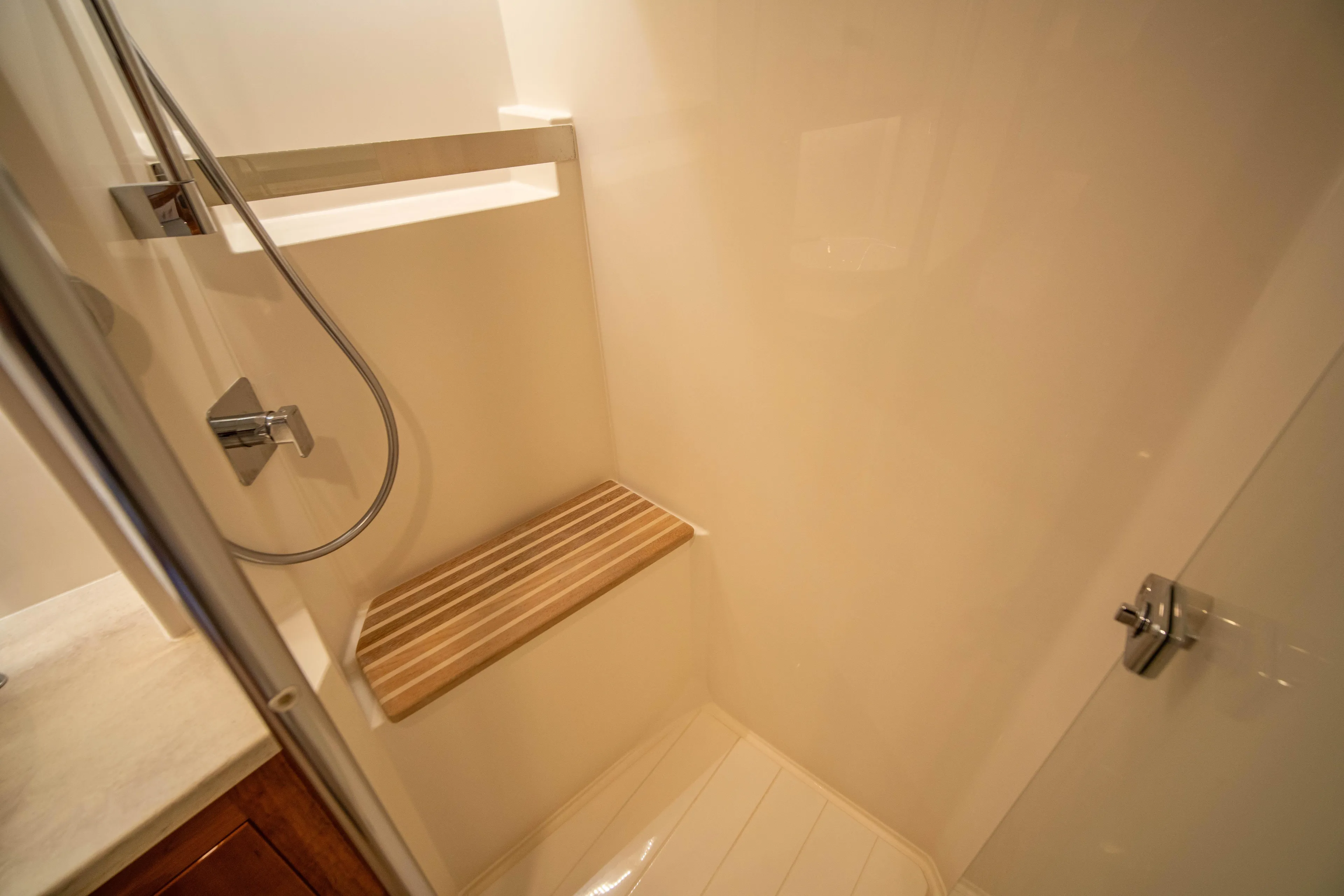  Yacht Photos Pics Luxurious shower in 2020 Riviera 525 SUV yacht with wooden bench and modern fixtures.
