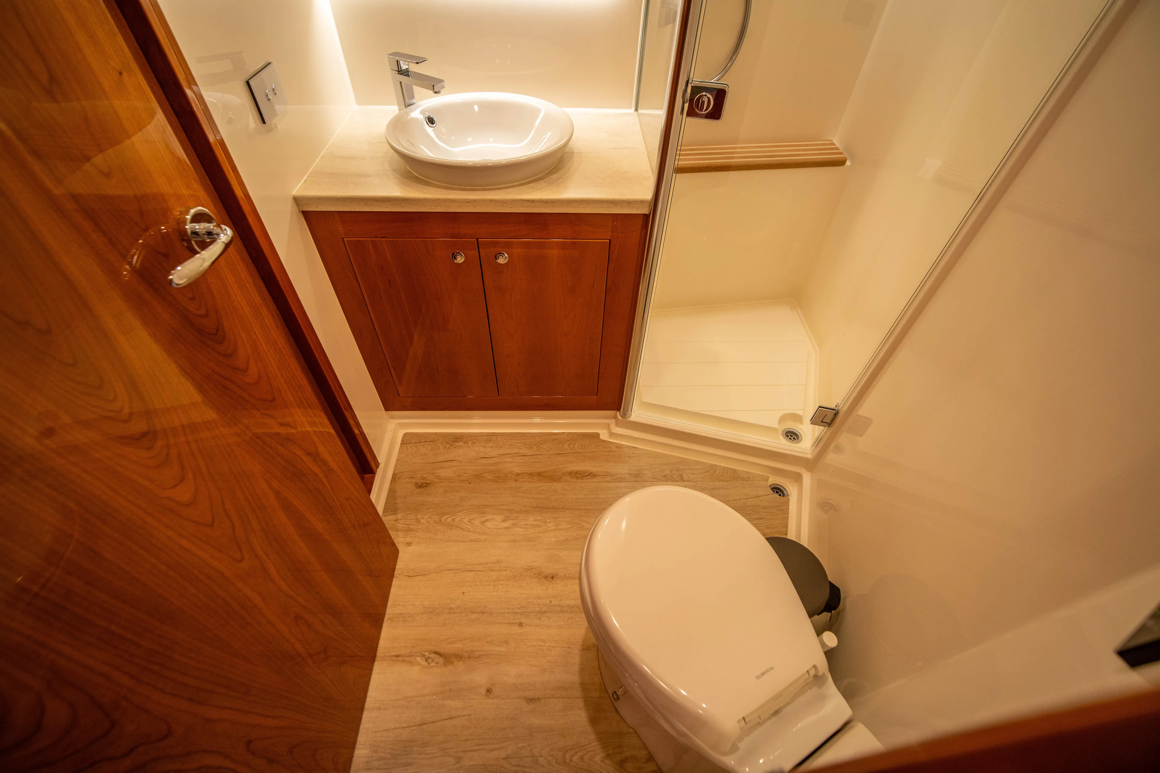  Yacht Photos Pics Luxurious bathroom in 2020 Riviera 525 SUV yacht with wood accents and modern fixtures.