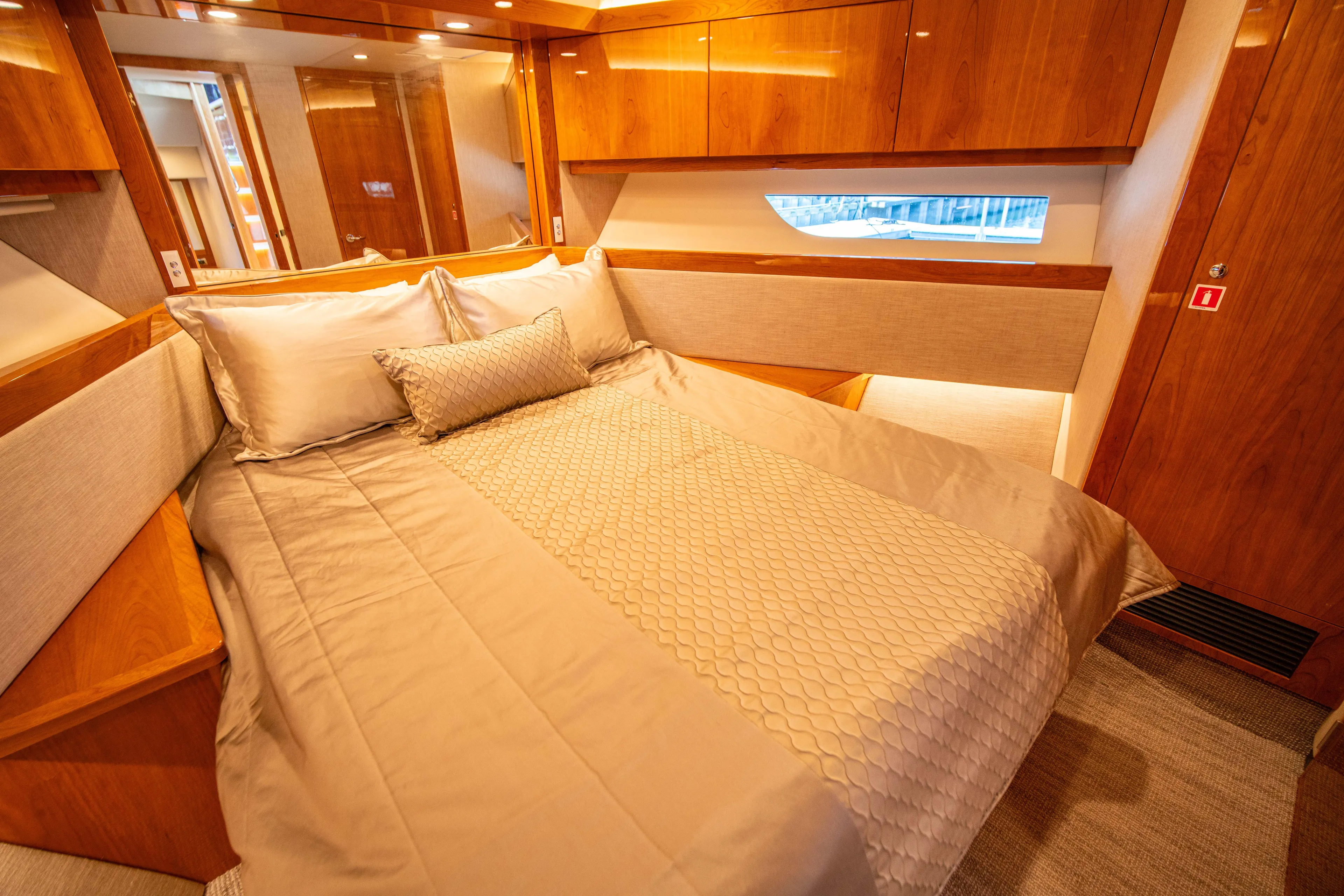  Yacht Photos Pics Luxurious bedroom interior of 2020 Riviera 525 SUV yacht with elegant wood finishes.