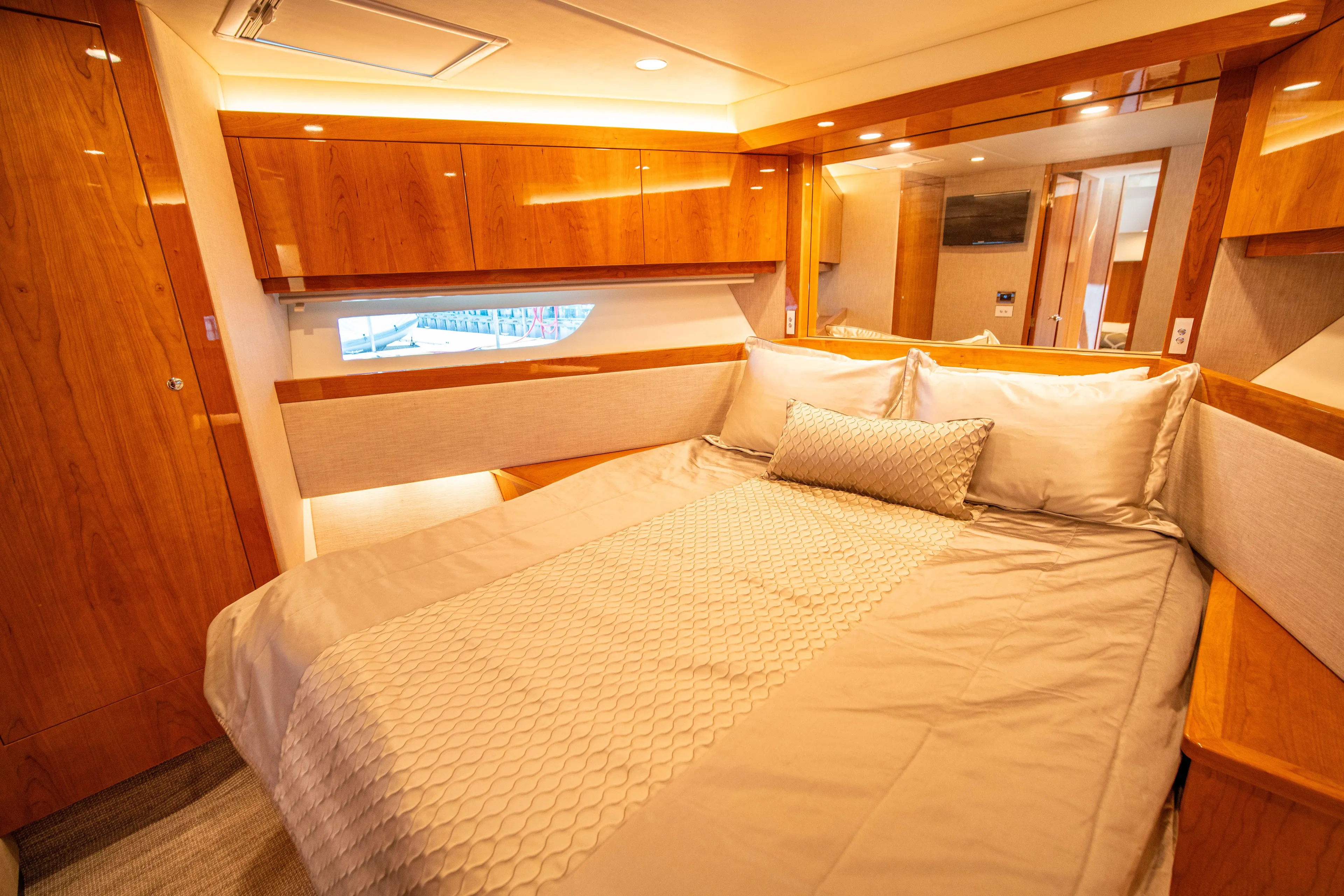  Yacht Photos Pics Luxurious bedroom interior of 2020 Riviera 525 SUV yacht with elegant wood finishes.
