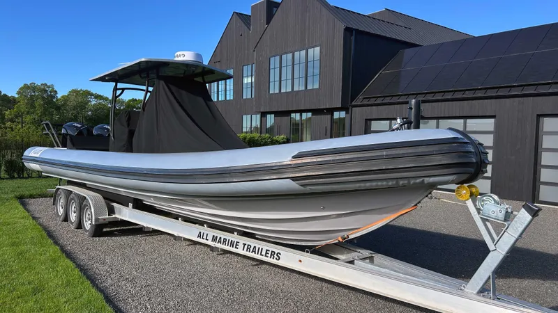  Yacht Photos Pics 2023 Fluid Watercraft M35 boat on trailer, parked near modern building.