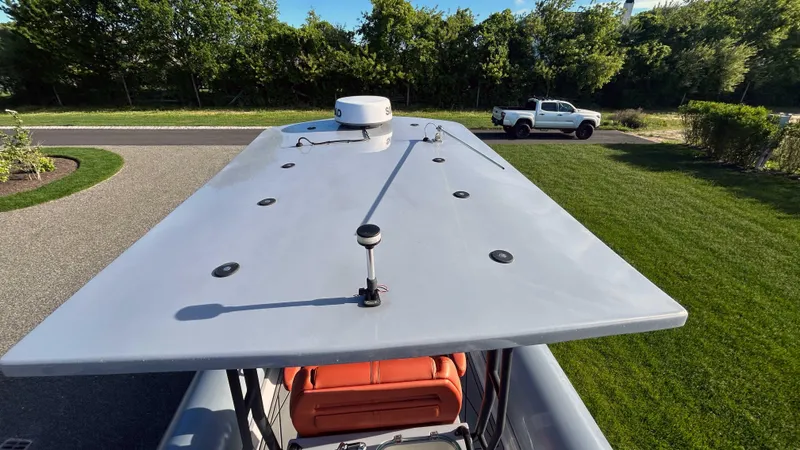  Yacht Photos Pics 2023 Fluid Watercraft M35 boat roof with radar, parked near a green lawn and white truck.