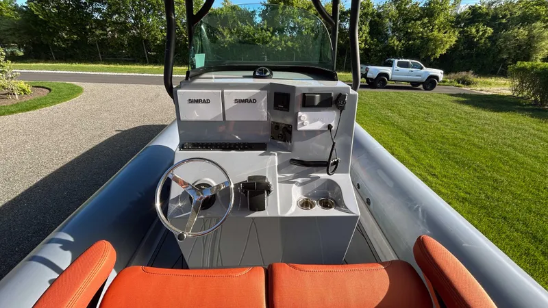  Yacht Photos Pics 2023 Fluid Watercraft M35 boat with orange seats and modern dashboard, parked on a driveway.