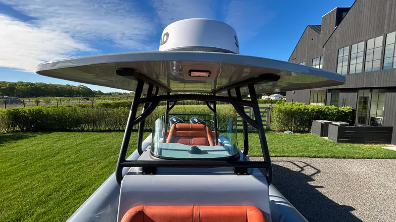  Yacht Photos Pics 2023 Fluid Watercraft M35 boat with sleek design, parked outdoors near modern building.