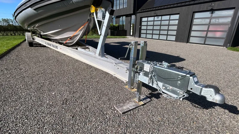  Yacht Photos Pics 2023 Fluid Watercraft M35 boat on trailer, parked on gravel driveway.