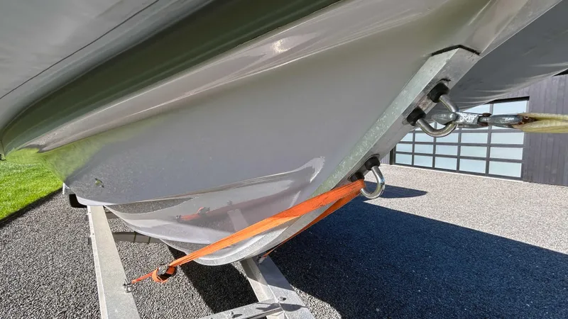  Yacht Photos Pics 2023 Fluid Watercraft M35 boat hull secured with orange strap on trailer.