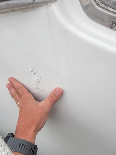 All In Yacht Photos Pics Hand inspecting damage on 2003 Robertson & Caine Lion 46 boat hull.