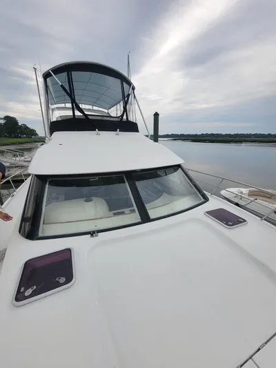 All In Yacht Photos Pics 2003 Robertson & Caine Lion 46 yacht docked by a serene waterfront.