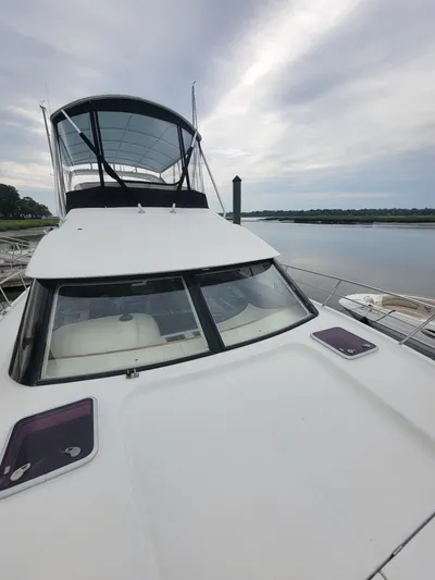 All In Yacht Photos Pics 2003 Robertson & Caine Lion 46 yacht docked by a serene waterfront.