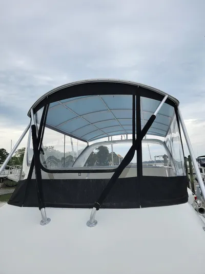 All In Yacht Photos Pics 2003 Robertson & Caine Lion 46 boat with canopy under cloudy sky.